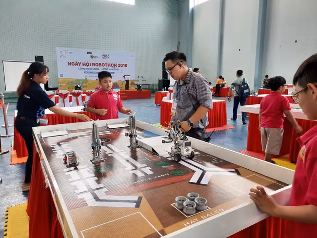 Trọng tài đang hướng dẫn các thí sinh cho robot thực hiện bài thi của mình.