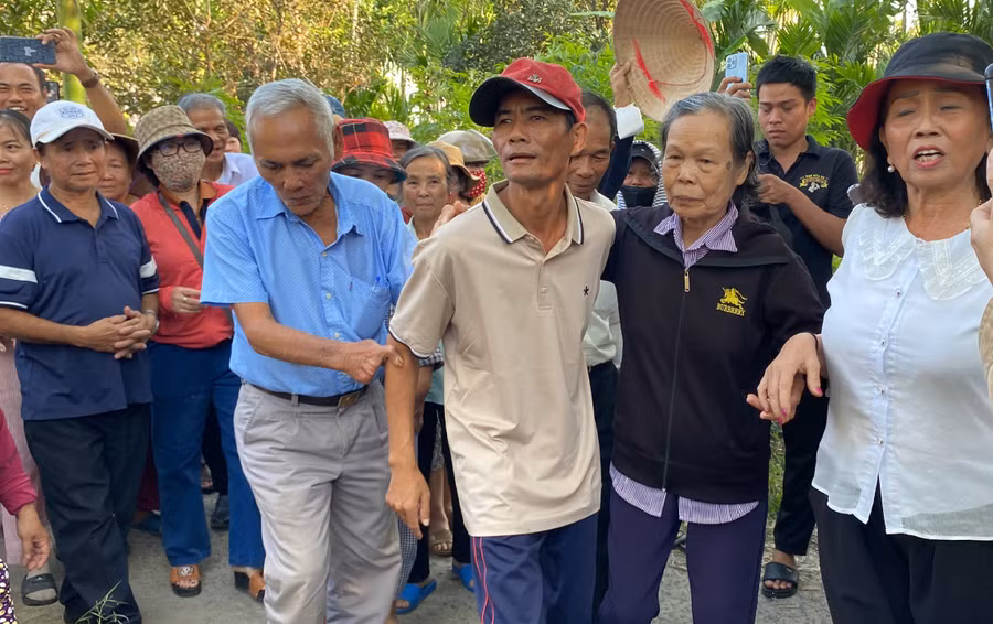 Bà Trần Thị Sốt (áo đen) đón anh Chung trở về.