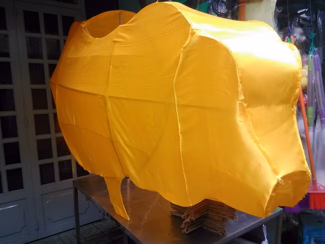Chiếc lồng đèn khổng lồ hình chú "Heo Vàng Kim" của cơ sở nhà anh Nguyễn Trọng Bình đang hoàn thiện cho khách với chất liệu bằng vải.