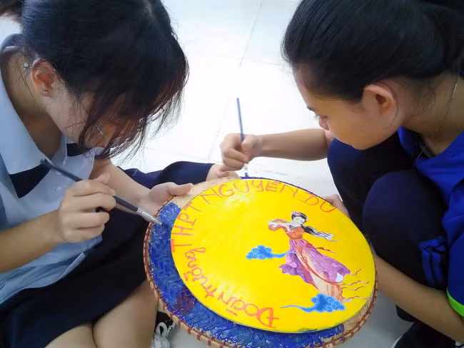 Các học sinh Trường THPT Nguyễn Du đang trang trí logo trường.