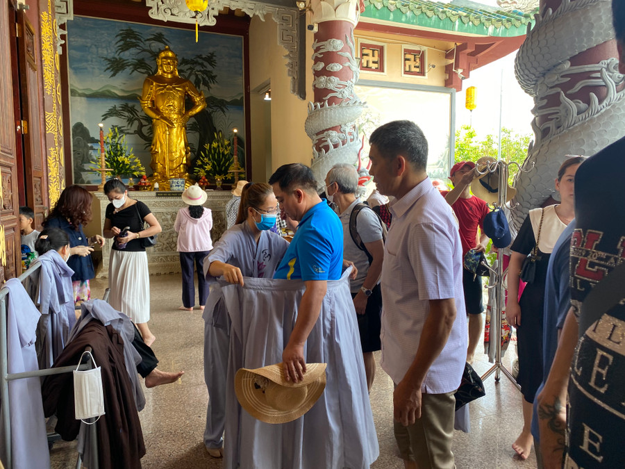 Du khách nếu mặc quần ngắn trên đầu gối sẽ được phát áo choàng trước khi vào chánh điện bái Phật. Ảnh: Hoàng Vinh. Du khách nếu mặc quần ngắn trên đầu gối sẽ được phát áo choàng trước khi vào chánh điện bái Phật. Ảnh: Hoàng Vinh.