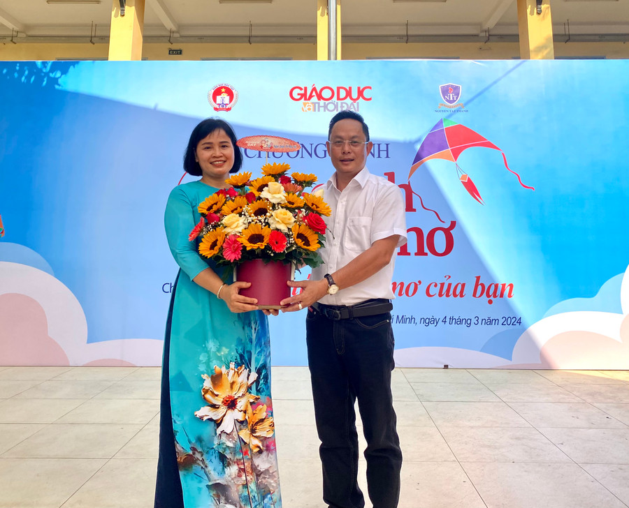 Nhà báo Nguyễn Anh Tú, Phó trưởng Cơ quan Thường trú Báo Giáo dục và Thời đại tại TP.HCM tặng hoa cho cô Hoàng Thị Hảo, Hiệu trưởng Trường THPT Đào Sơn Tây.