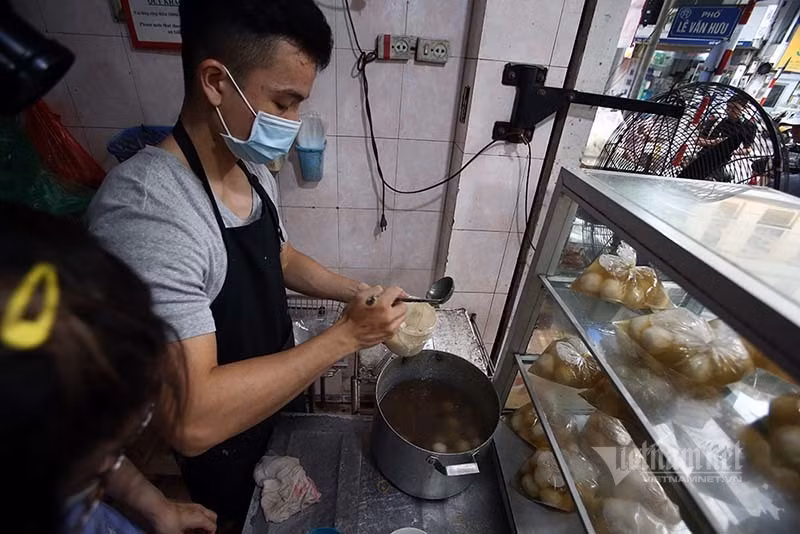 Bên trong cửa hàng, nhân viên làm việc hết công suất, tay thoăn thoắt múc bánh cho vào hộp cho khách. Bên trong cửa hàng, nhân viên làm việc hết công suất, tay thoăn thoắt múc bánh cho vào hộp cho khách.