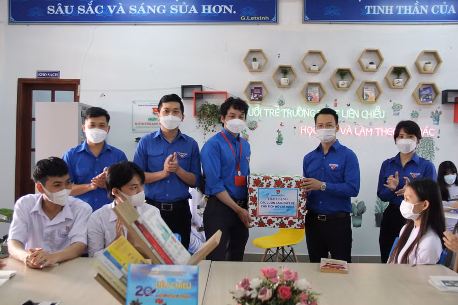 Anh Nguyễn Mạnh Dũng (áo xanh, thứ 2 từ phải sang) - Bí thư Thành đoàn Đà Nẵng trao tặng các cuốn sách viết về Chủ tịch Hồ Chí Minh cho Đoàn thanh niên Trường THPT Liên Chiểu.