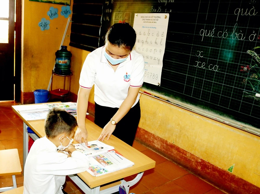 Cô giáo trường Tiểu học Khe Mo (Đồng Hỷ) hỗ trợ thêm ngoài giờ học cho một học sinh khuyết tật 