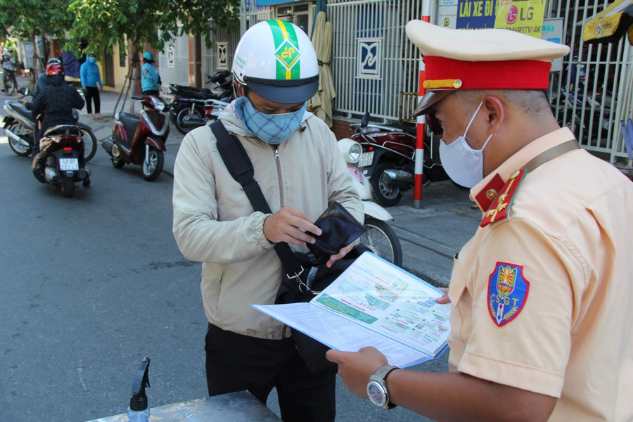 Lực lượng CSGT kiểm tra giấy tờ và thông tin người dân ở các chốt kiểm soát.