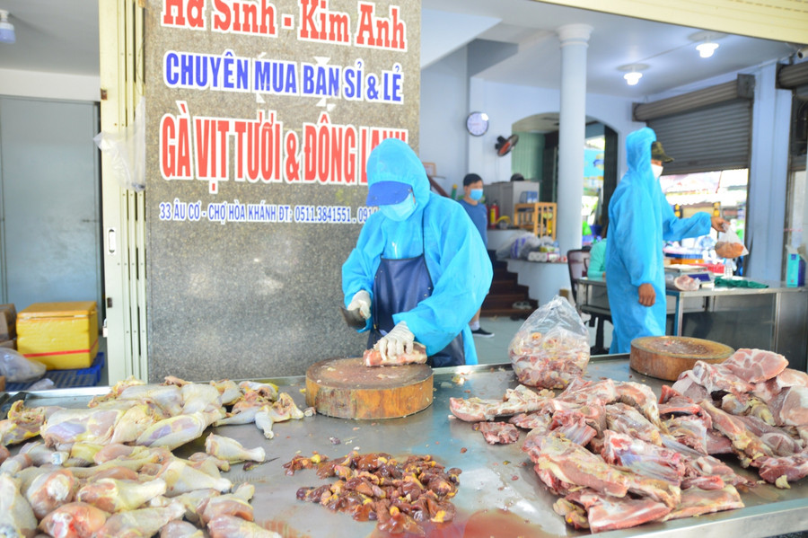 Các nhân viên tại cơ sở kinh doanh thịt gà, vịt, mặc đồ bảo hộ khi bán hàng.