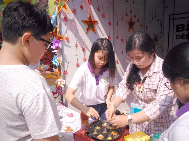 Các sinh viên trường ĐH Sư phạm TPHCM đang trổ tài làm món bánh trứng nướng cho các thực khách ghé thăm gian hàng.