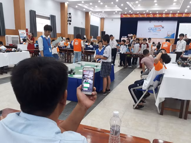 Phụ huynh tham gia cuộc thi ghi lại khoảnh khắc thi đấu cùng con.