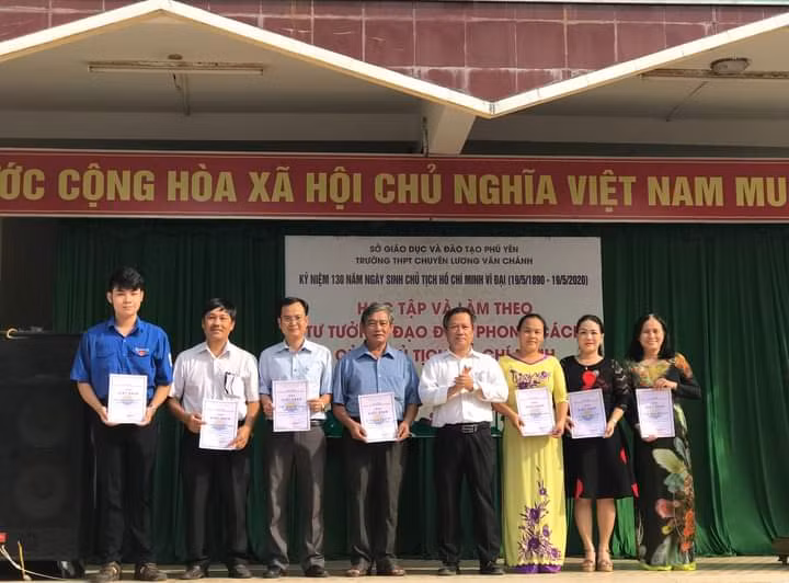 Cô Vy (áo dài vàng) được tặng giấy khen trong sự kiện do trường tổ chức.