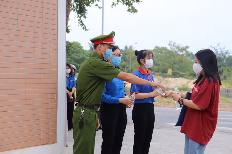 Cán bộ làm thi hướng dẫn thí sinh rửa tay sát khuẩn trước khi vào khu vực thi.