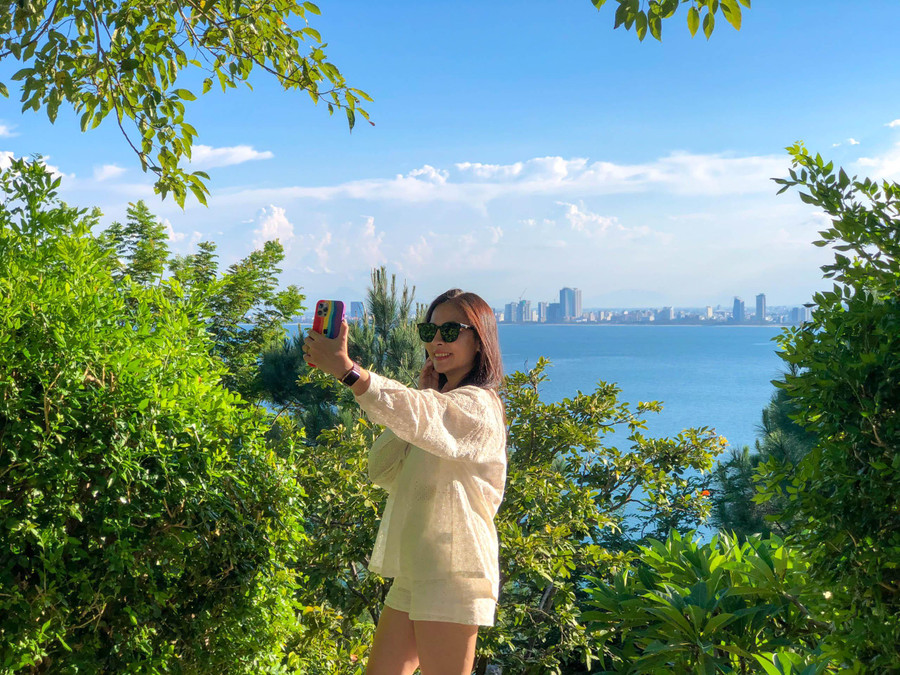 Một nữ du khách tranh thủ ghi lại hình ảnh thành phố khi nhìn từ Chùa Linh Ứng. Một nữ du khách tranh thủ ghi lại hình ảnh thành phố khi nhìn từ Chùa Linh Ứng.