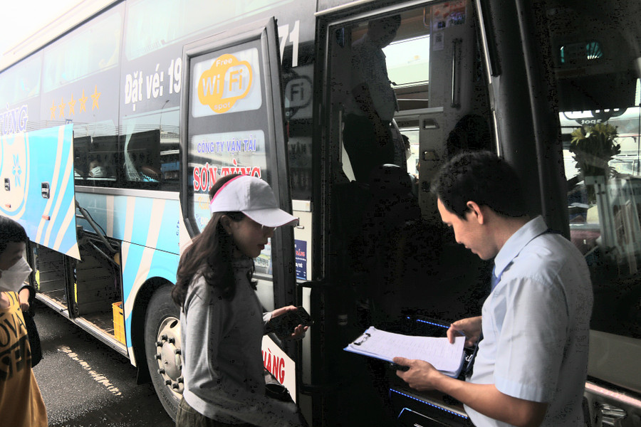 Hành khách kiểm tra thông tin, số ghế trước khi lên xe. Ảnh: H.Vinh.