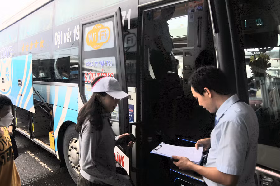 Hành khách kiểm tra thông tin, số ghế trước khi lên xe. Ảnh: H.Vinh.