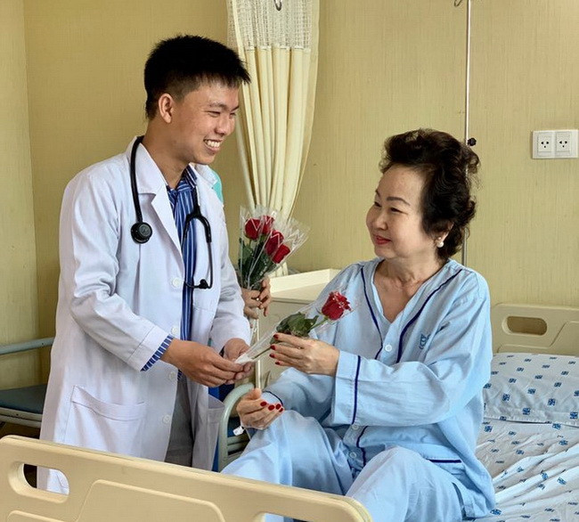 Bác sĩ tặng hoa cho nữ bệnh nhân.