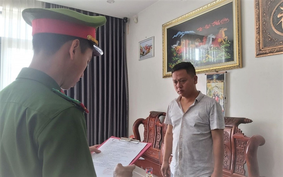 Công an tống đạt quyết định khởi tố bị can, bắt tạm giam 4 tháng đối với Xinh. Ảnh: Công an.