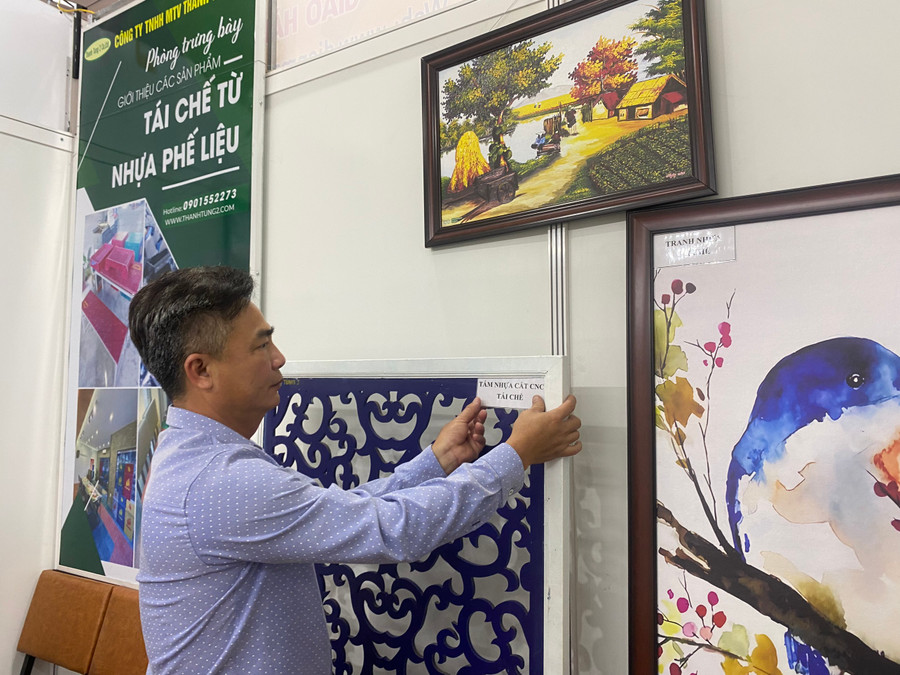 Anh Huỳnh Phước Lộc - Giám đốc Công ty TNHH MTV Thanh Tùng 2, trưng bày các sản phẩm được làm từ nhựa phế liệu tái chế. Ảnh: Hoàng Vinh.