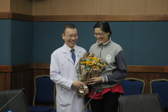 PGS TS BS. Nguyễn Hoàng Định tặng hoa cho chị Đ. (Ảnh: BVCC).