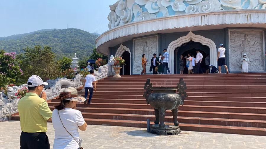 Bất chấp nắng nóng, nhiều du khách “đội nắng” để cầu nguyện dưới chân tượng Quán Thế Âm Bồ Tát.