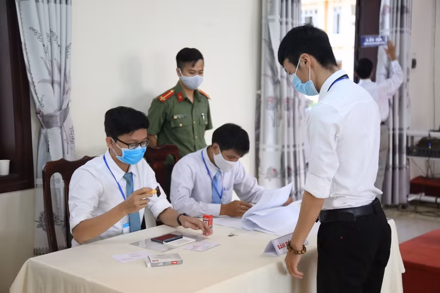 Sau khi thực hiện bỏ phiếu, tổ bầu cử đóng dấu vào thẻ cử tri cho sinh viên.