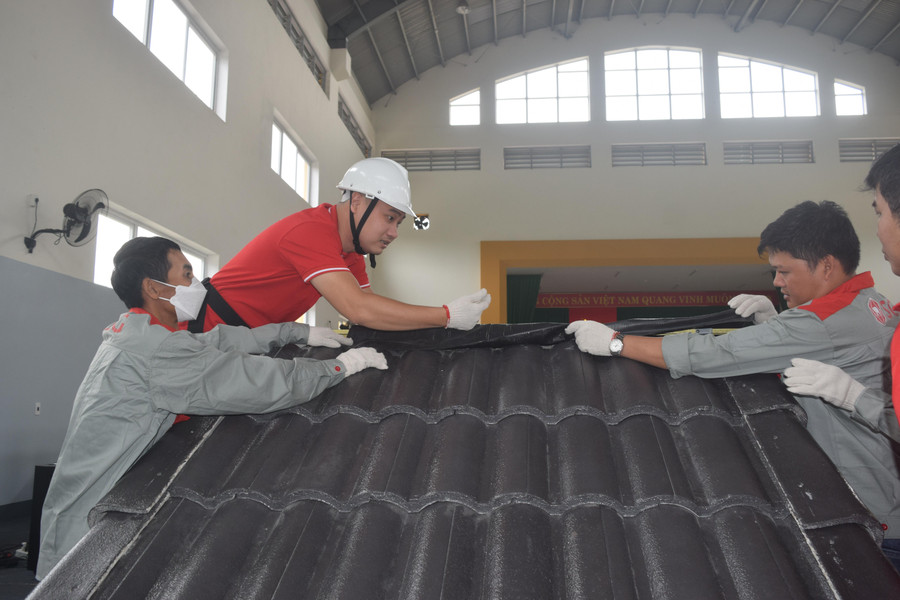 Các thí sinh thực hiện bài dự thi lợp mái ngói. Các thí sinh thực hiện bài dự thi lợp mái ngói.