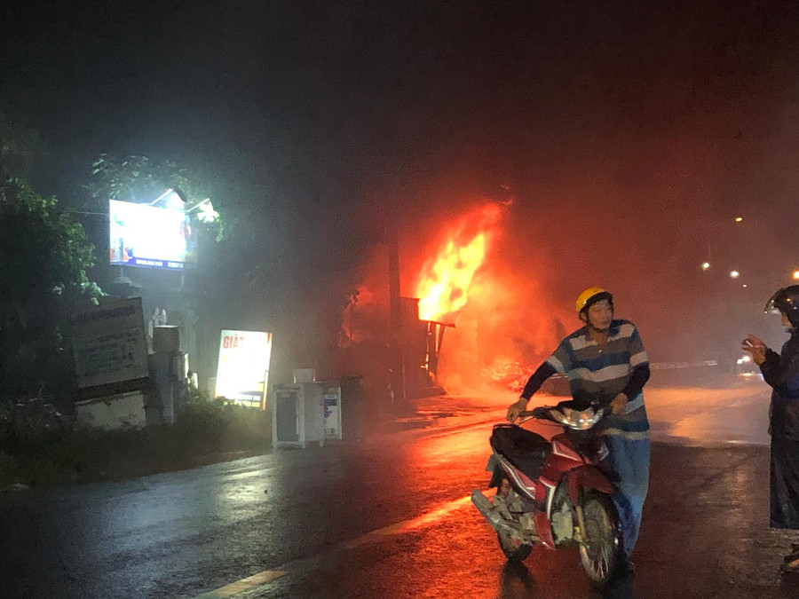 Người dân vội dắt xe di chuyển đến nơi an toàn, tránh xa kho phế liệu đang cháy.