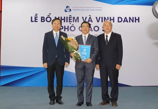 PGS.TS Mai Thanh Phong và Chủ tịch HĐ chức danh Giáo sư cơ sở - GS.TS Lê Tiến Thường trao quyết định và hoa chúc mừng tân PGS Nguyễn Trường Sơn