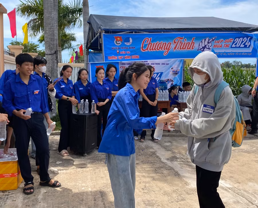 Tình nguyện viên phát nước cho thí sinh dự thi tại điểm Trường THPT Hùng Vương.