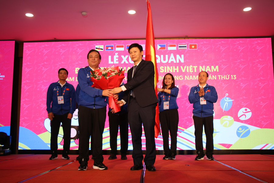 Ông Nguyễn Thanh Đề (áo vest) - Vụ trưởng Vụ Giáo dục Thể chất (Bộ GD&ĐT) trao cờ và tặng hoa cho Trưởng Đoàn Thể thao học sinh Việt Nam.
