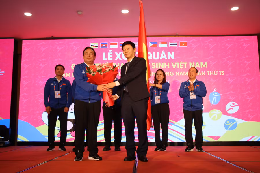 Ông Nguyễn Thanh Đề (áo vest) - Vụ trưởng Vụ Giáo dục Thể chất (Bộ GD&ĐT) trao cờ và tặng hoa cho Trưởng Đoàn Thể thao học sinh Việt Nam.