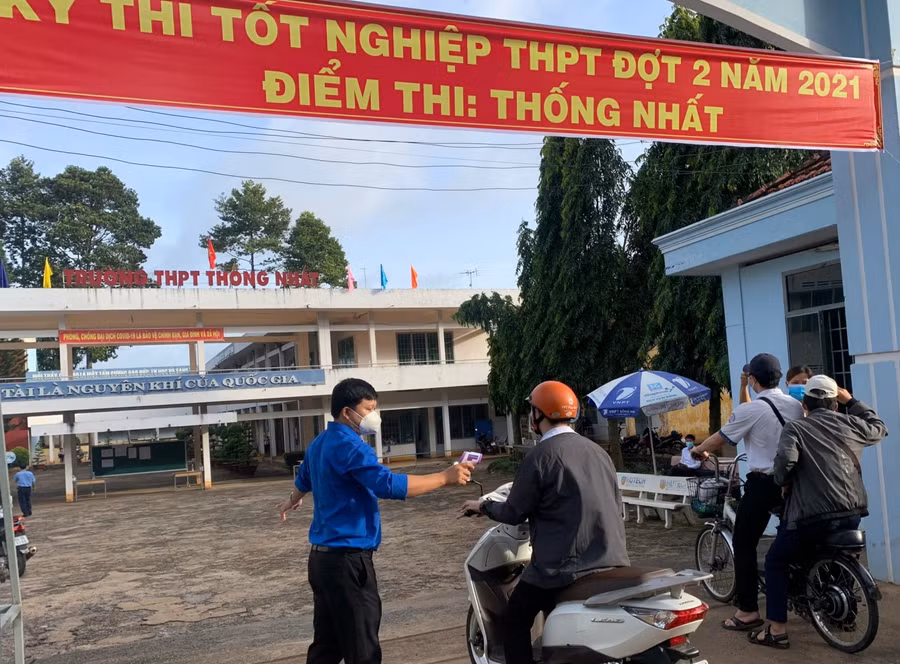 Lực lượng tình nguyện có mặt rất sớm hỗ trợ đo thân nhiệt, sát khuẩn tay cho thí sinh trước khi vào phòng thi để đảm bảo phòng dịch Covid-19 (Ảnh: Đoàn Thanh niên huyện Thống Nhất)