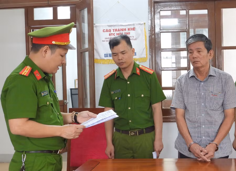 Công an tống đạt quyết định khởi tố bị can, thực hiện Lệnh bắt bị can để tạm giam đối với Đinh Ngọc Bình. (Ảnh: Công an Đà Nẵng)