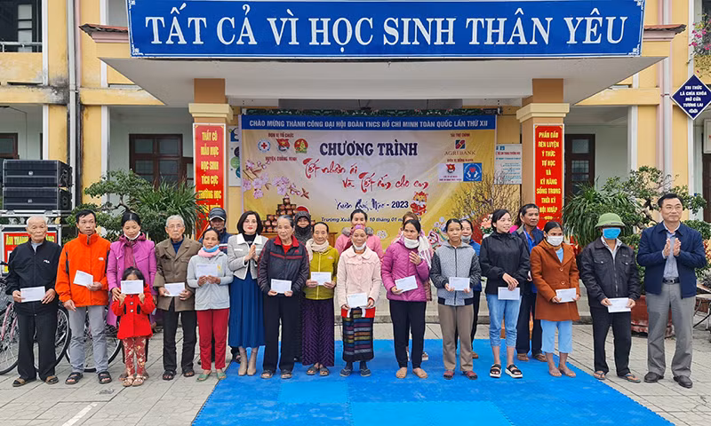 Các hộ dân có hoàn cảnh khó khăn đón nhận các phần quà từ Chương trình “Tết nhân ái” và Ngày hội “Tết ấm cho em” xuân Quý Mão năm 2023. Ảnh: L.C.
