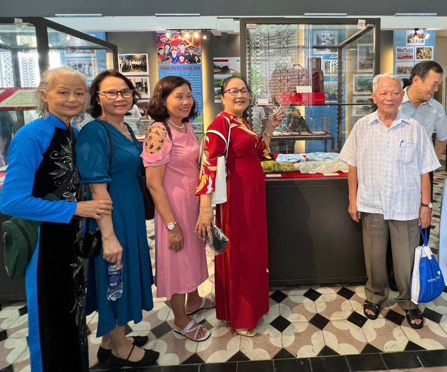 Bà Bùi Ngọc Ánh (ngoài cùng bên trái) và bà Lê Thị Xuân Thu (áo dài đỏ) chụp ảnh cùng với những bạn bè cùng lớp năm xưa.