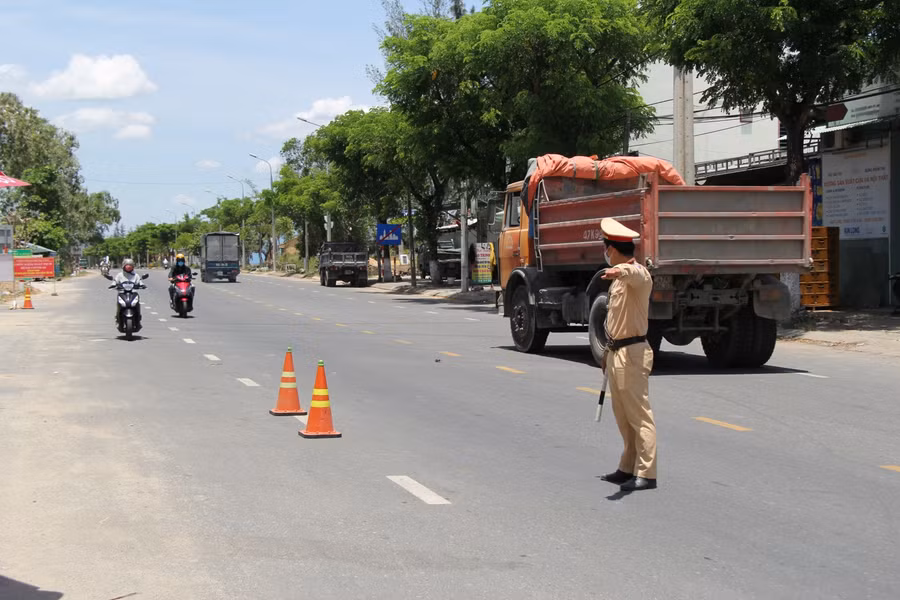 Lực lượng CSGT vất vả điều khiển phương tiện khai báo y tế dưới nắng nóng gần gần 40 độ.