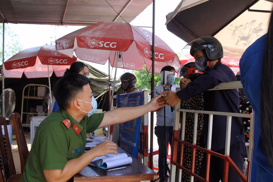 Công an hỗ trợ người dân khai báo y tế trước khi vào thành phố.