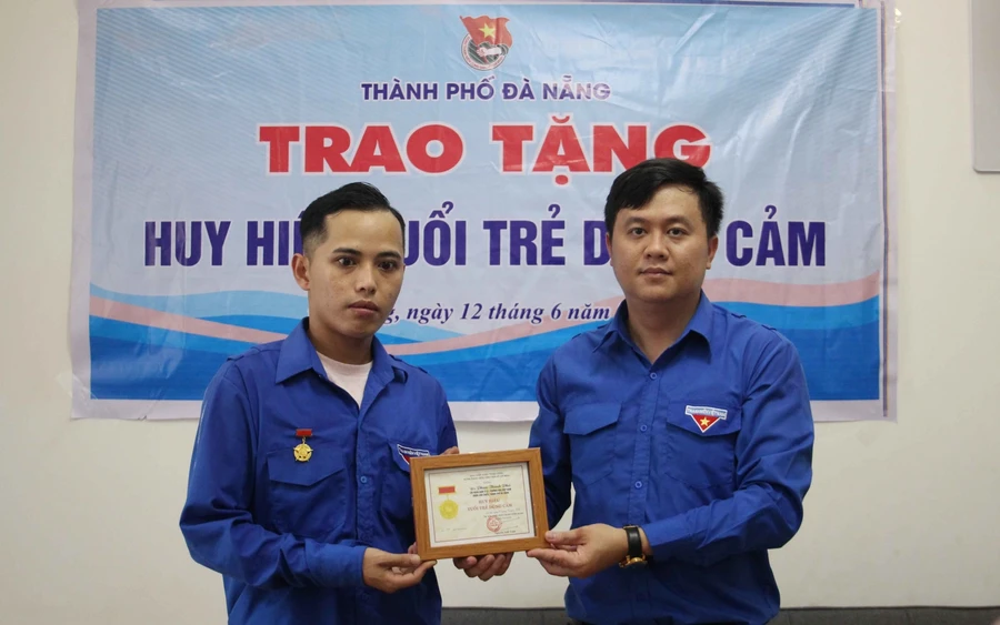 Anh Lê Công Hùng - Phó Bí thư Thành đoàn Đà Nẵng thừa ủy quyền của Trung ương Đoàn, đã trao Huy hiệu “Tuổi trẻ dũng cảm” cho đoàn viên Phan Thanh Phú. Ảnh: Thành đoàn Đà Nẵng. 