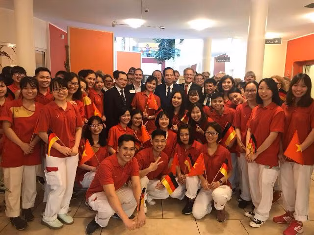 Bộ trưởng Bộ LĐ-TB&XH Đào Ngọc Dung chụp ảnh lưu niệm với các điều dưỡng viên Việt Nam tại Đức