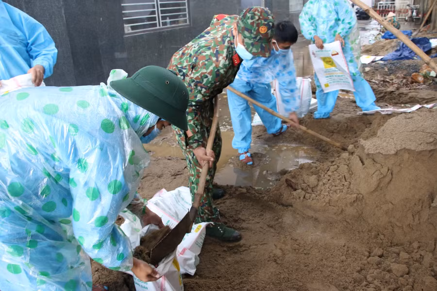 Gần 50 chiến sĩ Trung đoàn 971 thuộc Bộ Chỉ huy Quân sự TP Đà Nẵng xúc cát chằng chống nhà cửa giúp cho người dân.