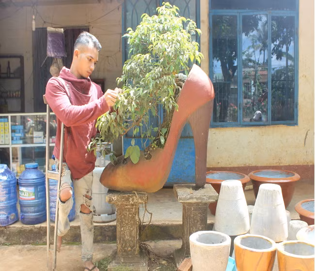 Y Phăng bên chậu cảnh hình chiếc giày, sản phẩm "độc đáo" khác biệt do anh thiết kế.