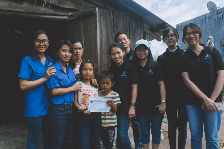 Cô giáo Tiền (thứ 2, trái sang) trao quà cho các em có hoàn cảnh khó khăn