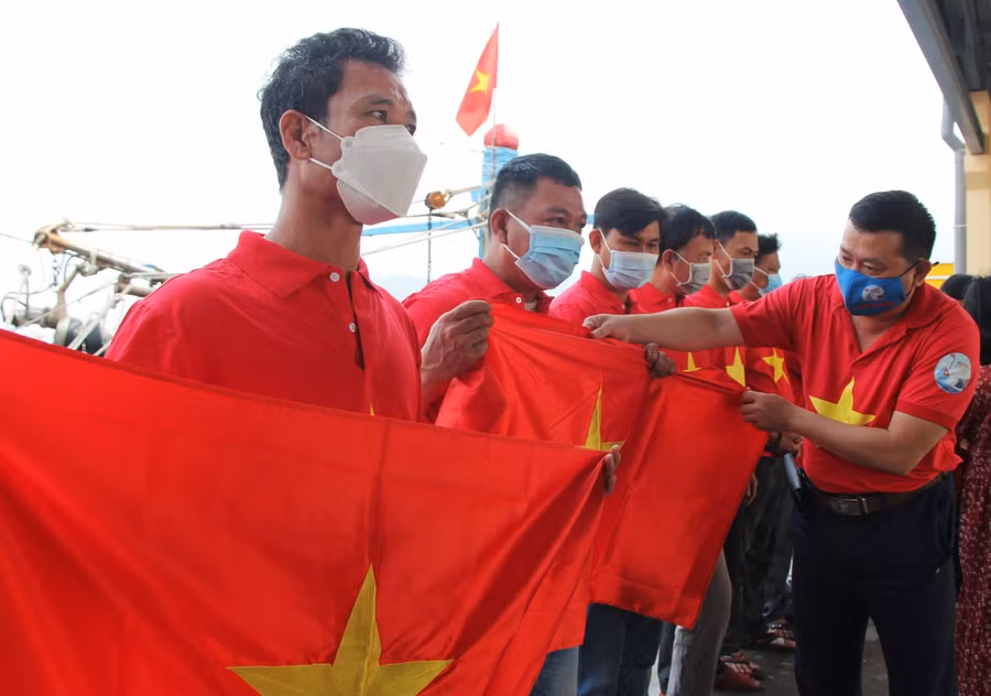 Đại diện Báo Người Lao động trao cờ Tổ quốc cho ngư dân. 