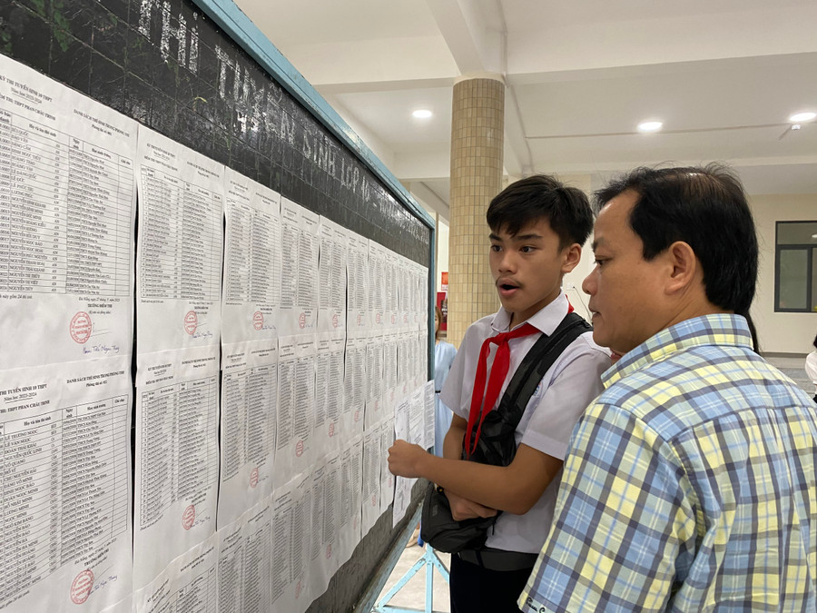 Phụ huynh cùng con xem danh sách phòng thi. Ảnh: Hoàng Vinh.