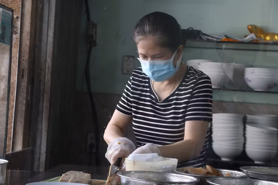 Bà Liên đang làm đồ ăn giao cho khách. Bà Liên cho biết bà sẽ thực hiện nghiêm 5K, cũng như các biện pháp đảm bảo an toàn phòng dịch trong thời gian mở cửa bán cho khách mang về.