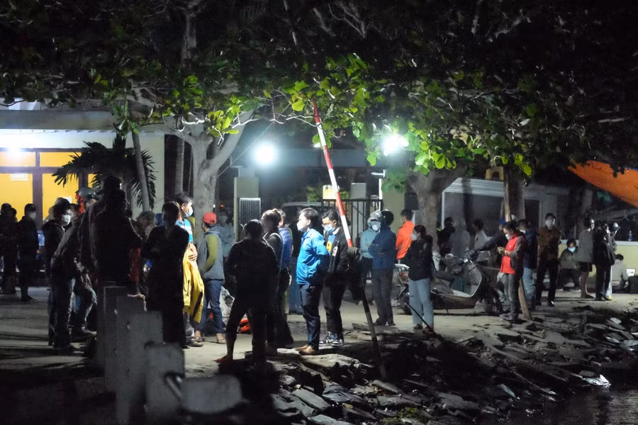 Người dân và người thân đang đứng trên bờ chờ tin tức từ lực lượng chức năng.