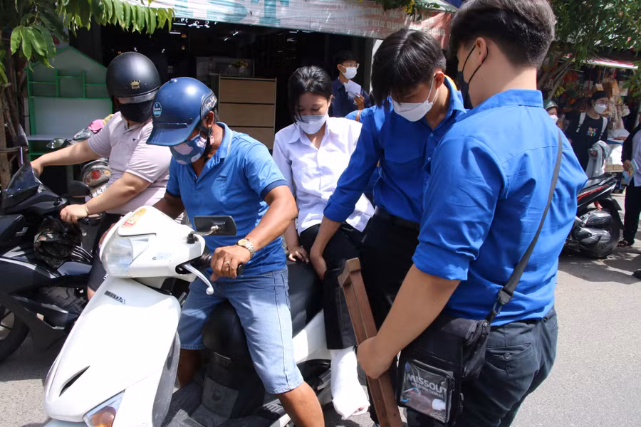 Thí sinh Hà Thúy L. được các tình nguyện viên hỗ trợ đưa ra xe sau khi hoàn thành bài thi.