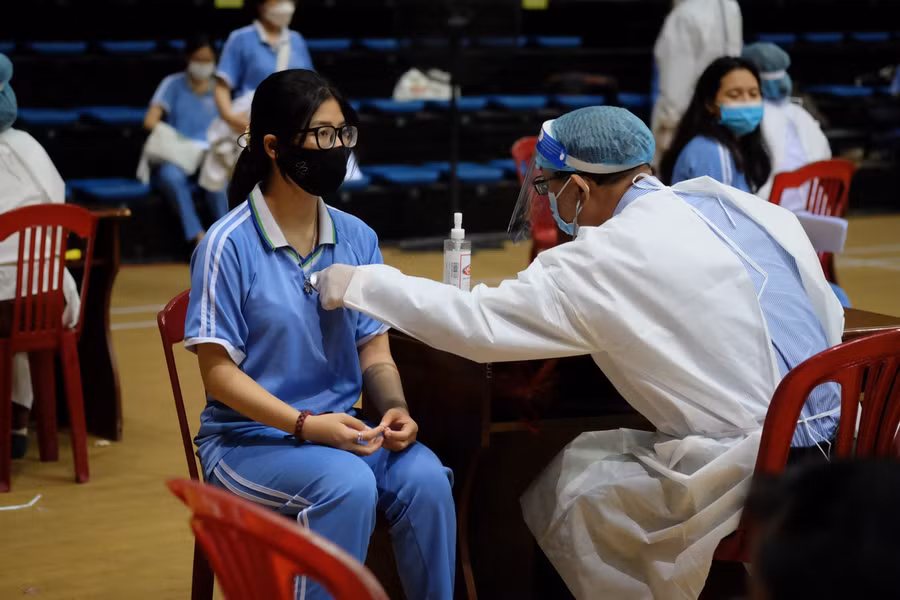 Học sinh được kiểm tra thông tin, khám sàng lọc trước khi tiêm chủng.