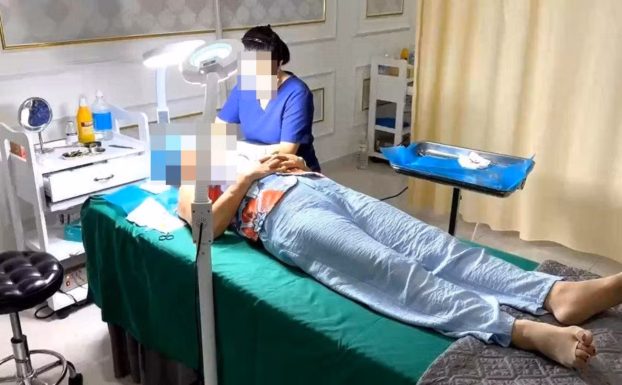 Nhân viên cơ sở thẩm mỹ Kangzin đang phẫu thuật làm đẹp cho khách hàng thời điểm kiểm tra. (Ảnh: Công an Thanh Khê)