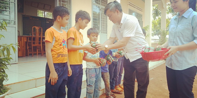 Thầy Nguyễn Thế Anh -Hiệu trưởng Nhà trường tặng những chiếc bánh đầu tiên cho học sinh.