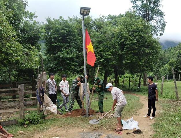 Bộ đội Biên phòng Làng Mô và người dân bản Dốc Mây dựng các cột đèn. Ảnh: Thanh Nam. Bộ đội Biên phòng Làng Mô và người dân bản Dốc Mây dựng các cột đèn. Ảnh: Thanh Nam.